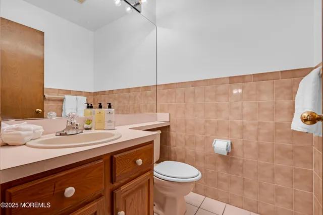 a bathroom with a granite countertop sink a toilet and a mirror