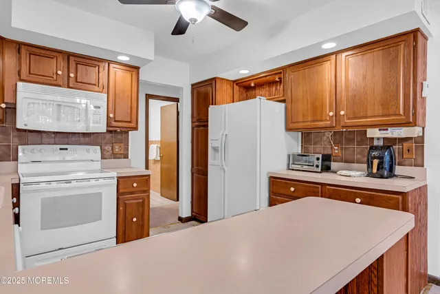 a kitchen with stainless steel appliances granite countertop a refrigerator sink stove microwave and cabinets