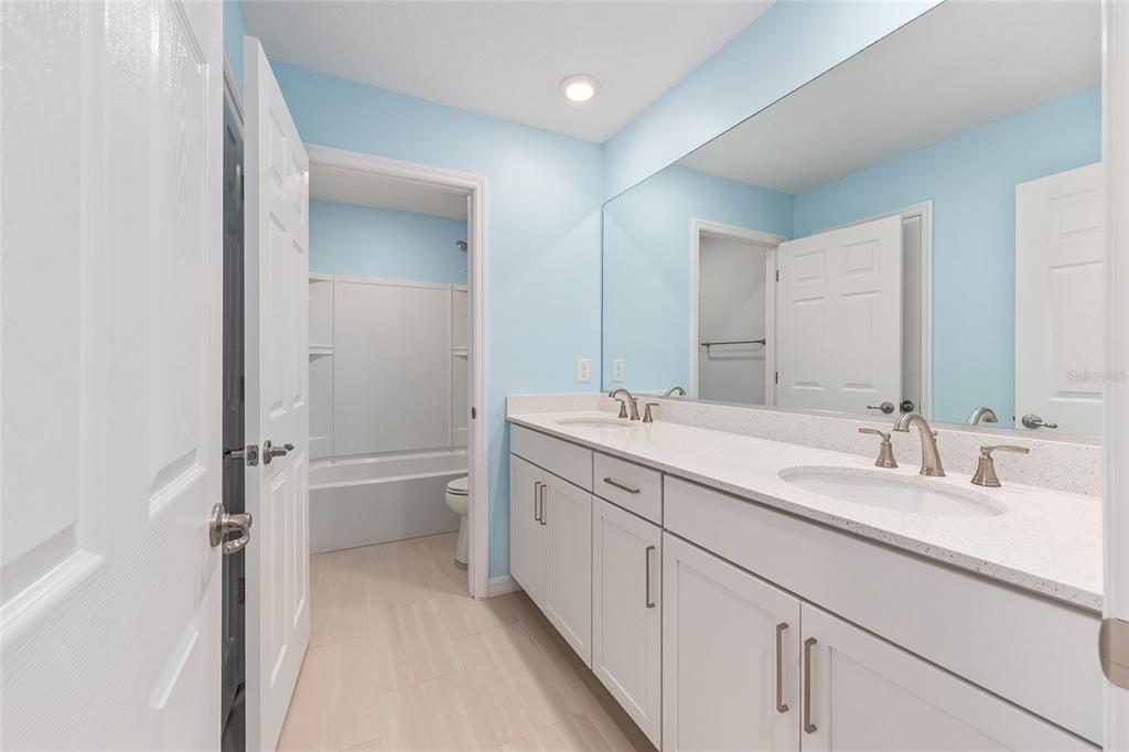6366 Southwest 77th Avenue Ocala, FL 34474 - Photo 20 of 65 a bathroom with a double vanity sink toilet and mirror