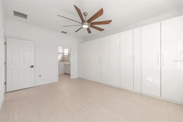 a view of an empty room with a ceiling fan