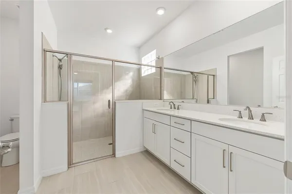 a view of a livingroom with a flat screen tv kitchen view and a refrigerator
