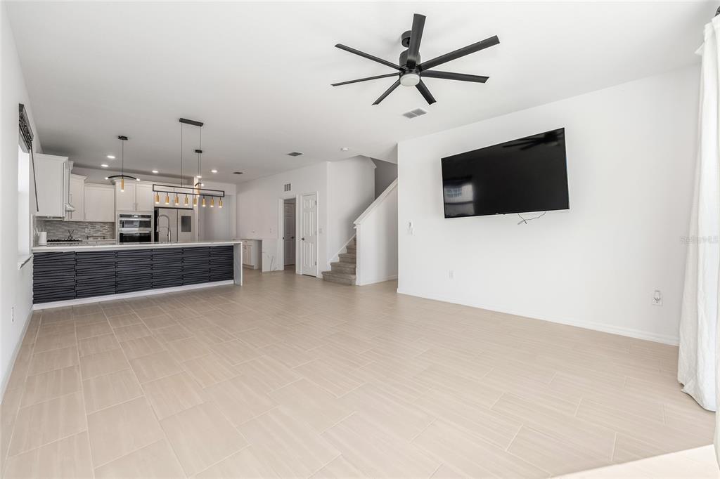 6366 Southwest 77th Avenue Ocala, FL 34474 - Photo 37 of 65 a view of a livingroom with a flat screen tv kitchen view and a refrigerator