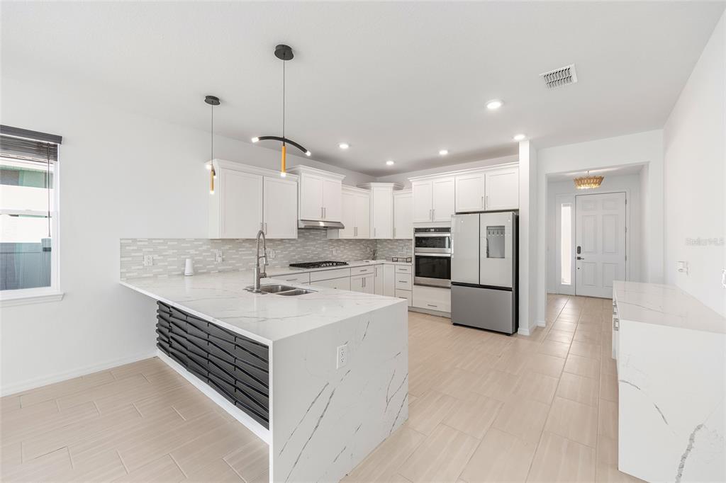 6366 Southwest 77th Avenue Ocala, FL 34474 - Photo 40 of 65 a kitchen with a sink a stove a refrigerator and white cabinets