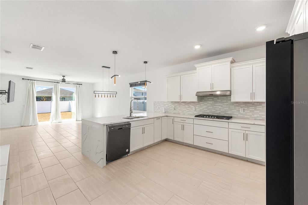 6366 Southwest 77th Avenue Ocala, FL 34474 - Photo 41 of 65 a large white kitchen with granite countertop a stove top oven a sink a counter space and cabinets