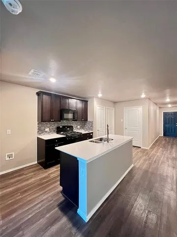 a large kitchen with stainless steel appliances a sink dishwasher a stove and a refrigerator