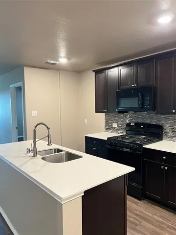 a kitchen with a sink cabinets and stainless steel appliances