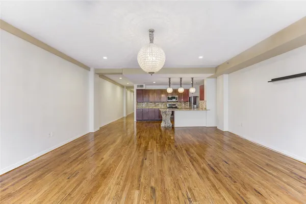 a kitchen with granite countertop cabinets stainless steel appliances and wooden floor