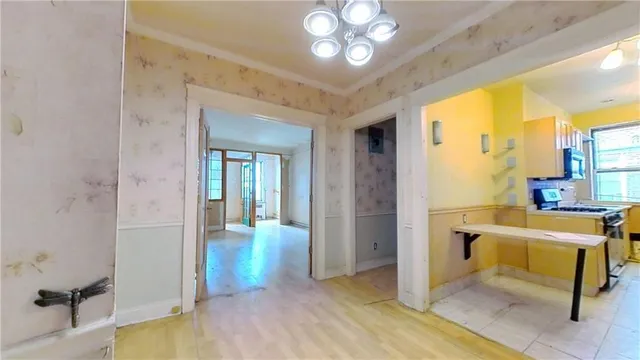 a view of a dining room with furniture a chandelier and wooden floor