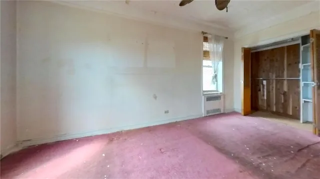 an empty room with closet and a window