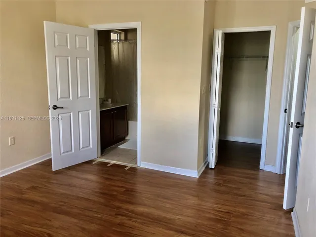 an empty room with wooden floor and closet