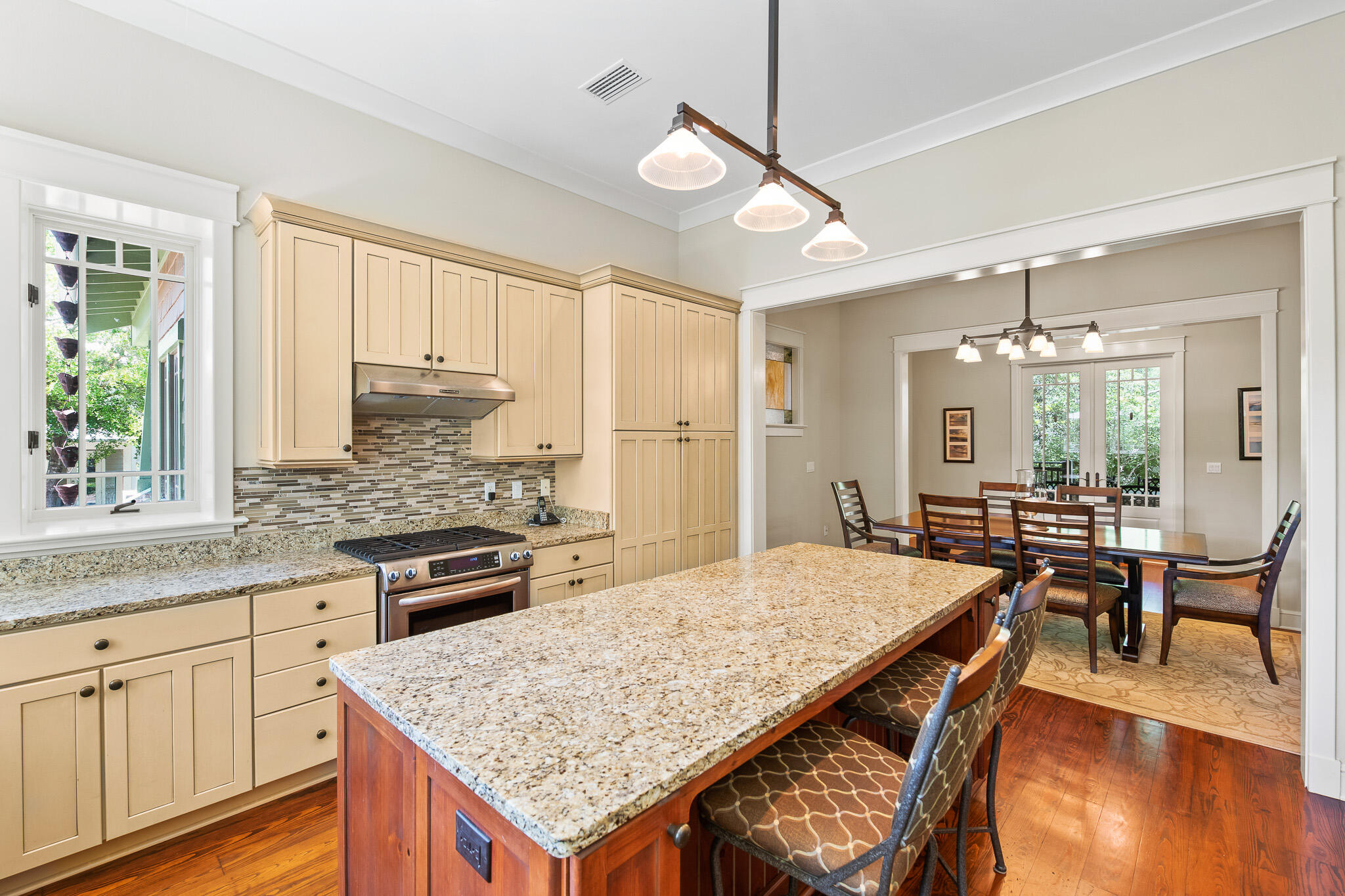 106 Okeechobee West Santa Rosa Beach, FL 32459 - Photo 14 of 53 a kitchen with granite countertop a stove a sink a dining table and chairs with wooden floor