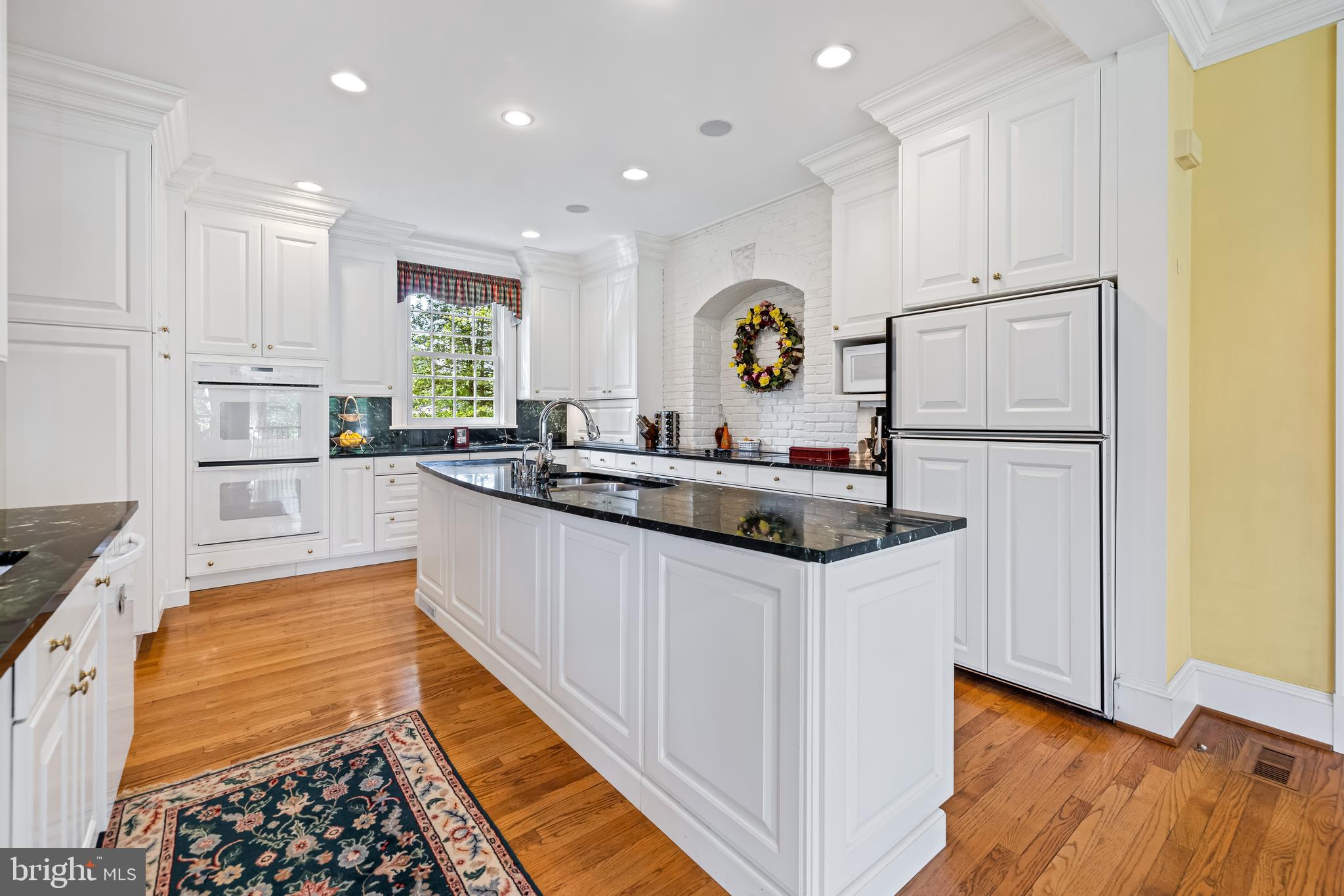 508 Hampton Lane Baltimore, MD 21286 - Photo 19 of 74 a kitchen with granite countertop a sink a stove a refrigerator and white cabinets with wooden floor