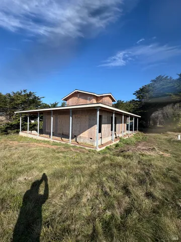 a white house with a big yard and a large tree