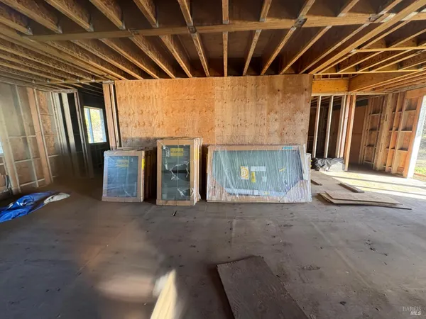 a view of an empty room with a fireplace and window