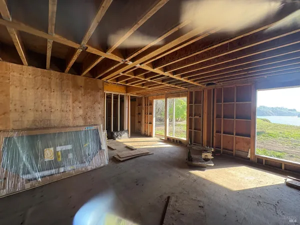 a view of an empty room with a fireplace and a window