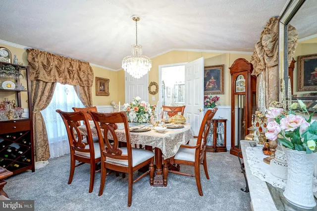 a dining room with furniture a chandelier and window