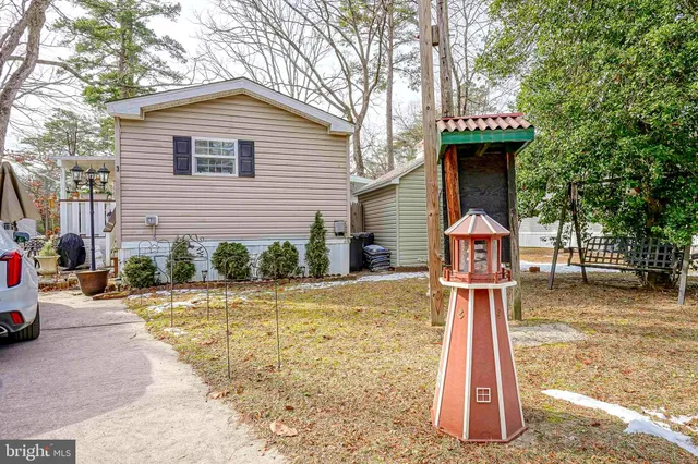 a front view of a house with a yard and trees