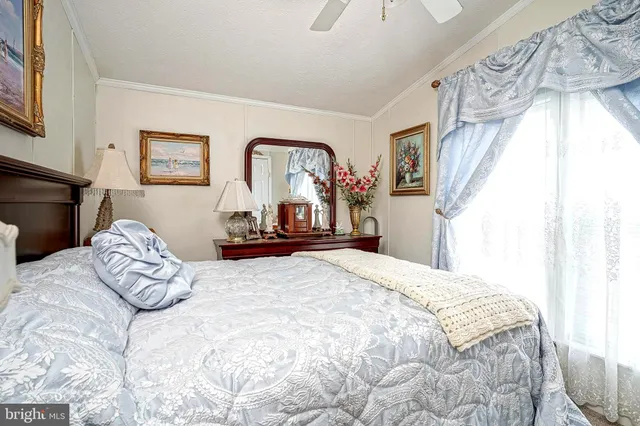 a bedroom with a bed and a large mirror on the dresser