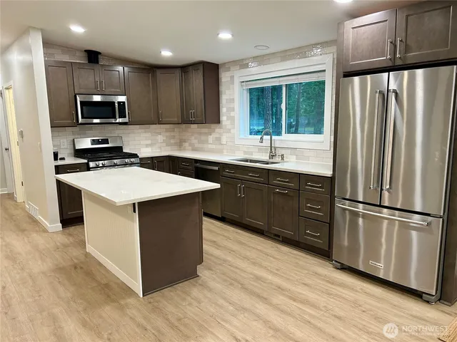 a kitchen with stainless steel appliances granite countertop a stove a refrigerator and a microwave