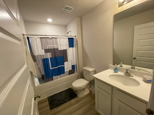 a bathroom with a sink a toilet a mirror and shower