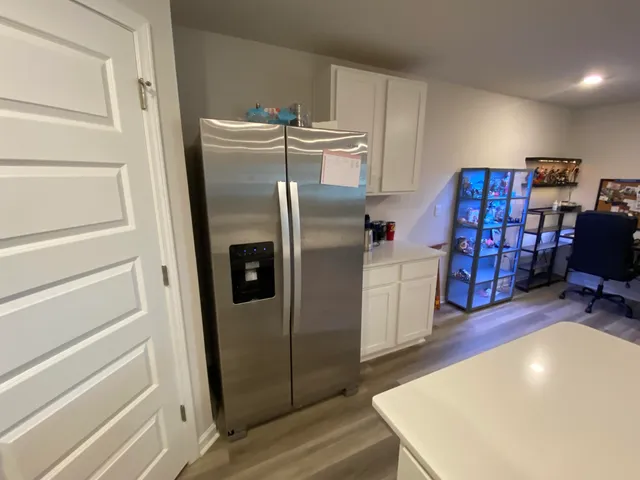 a view of a kitchen with fridge and workspace
