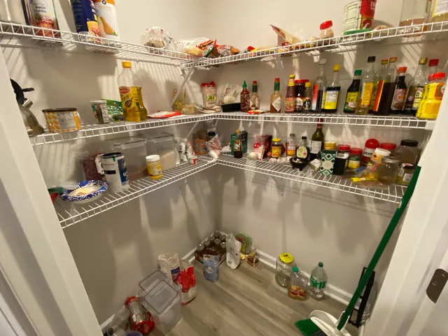 a room with water heater and shelf with wooden floor