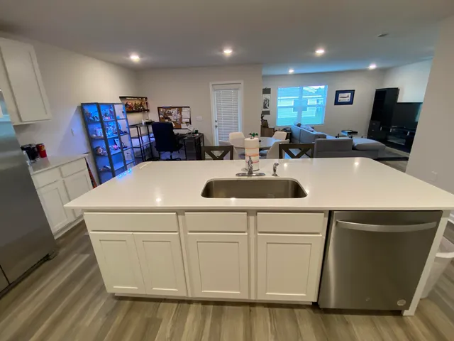 a view of kitchen with kitchen island a sink a stove and chairs