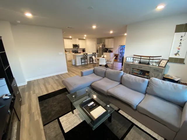 a living room with furniture and view of kitchen