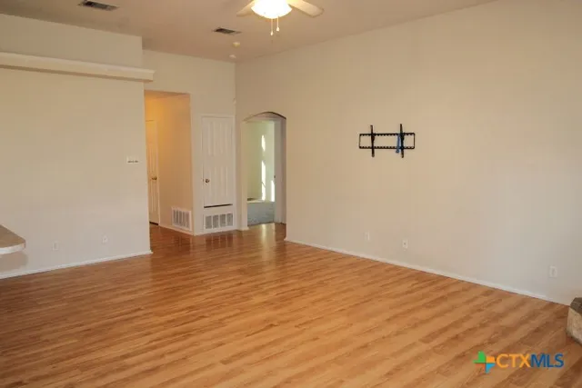 a view of empty room with wooden floor