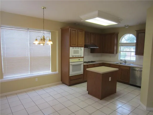 a kitchen with a stove a sink and a refrigerator