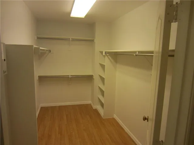 a view of walk in closet with empty racks