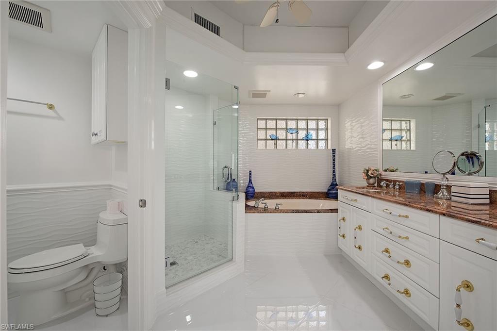 325 Dunes Boulevard, Unit 607 Naples, FL 34110 - Photo 5 of 27 a bathroom with a granite countertop sink mirror vanity and toilet