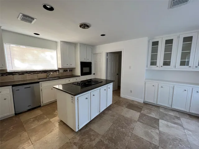a kitchen with granite countertop a sink and a stove