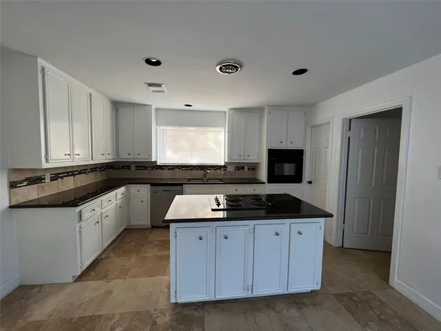 a kitchen with granite countertop a sink and cabinets