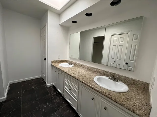 a bathroom with a granite countertop sink and a mirror