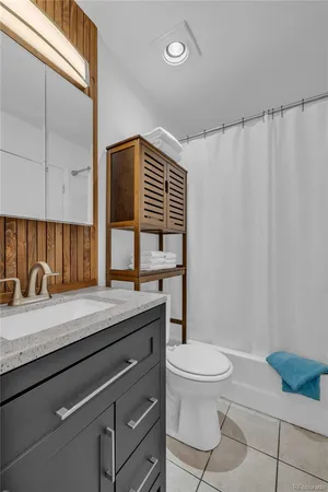a bathroom with a granite countertop sink toilet and mirror