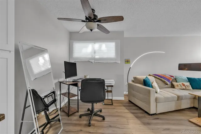 a kitchen with a refrigerator a stove top oven a wooden floor and cabinets