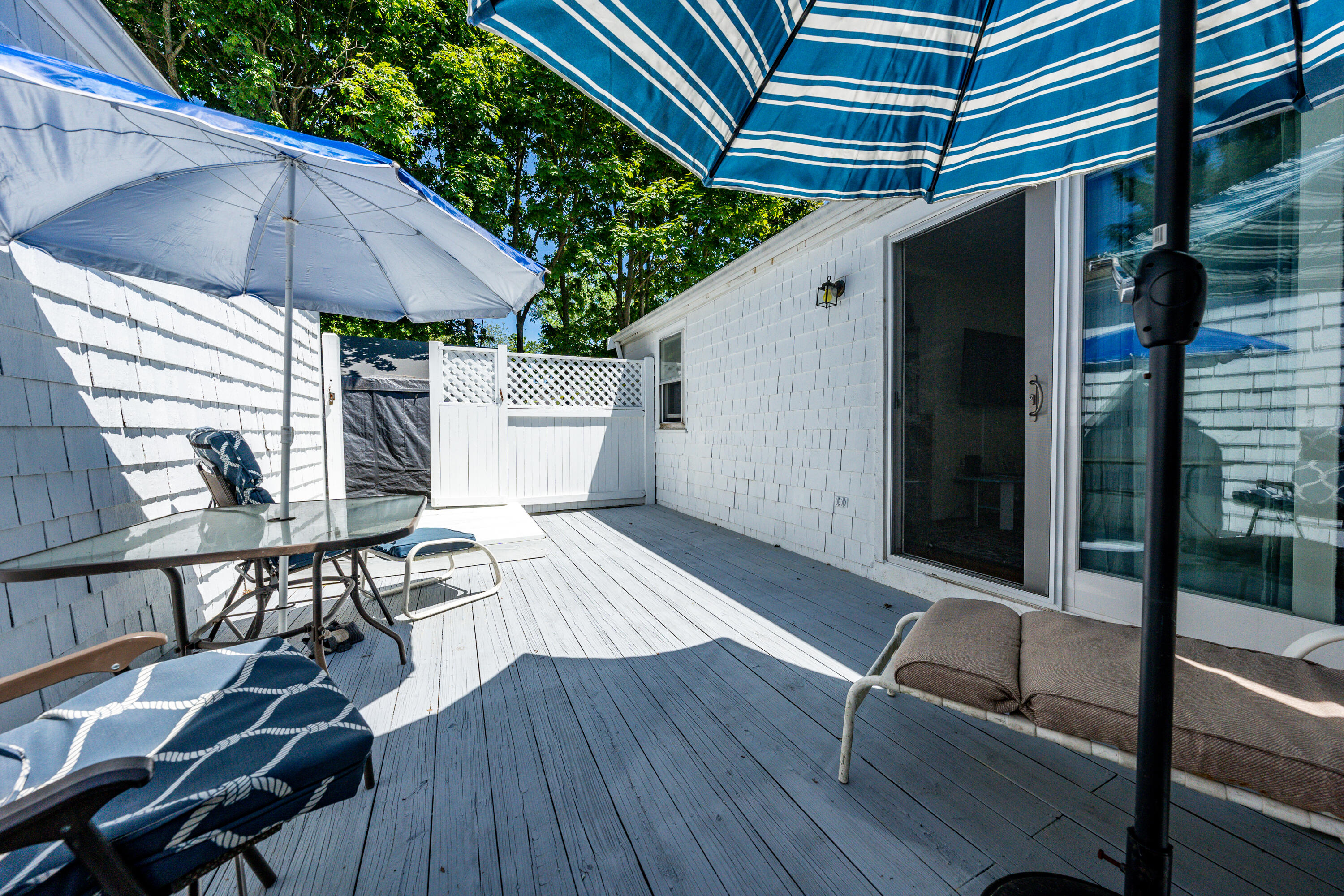 40 Seabrook Road Hyannis, MA 02601 - Photo 24 of 45 a view of a patio with table and chairs under an umbrella with wooden floor