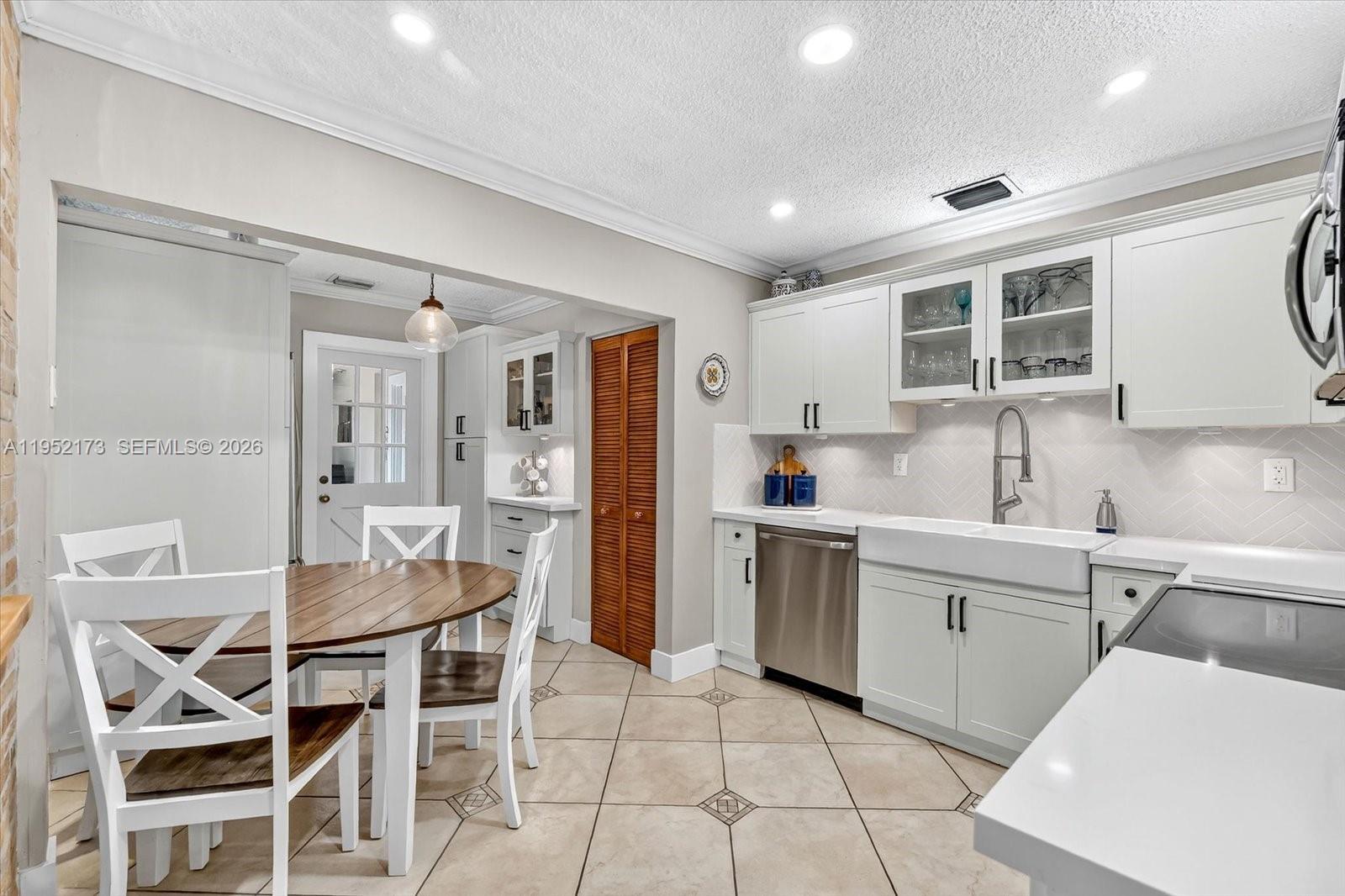 1300 West 77th Street Hialeah, FL 33014 - Photo 12 of 41 a kitchen with a table chairs refrigerator and cabinets