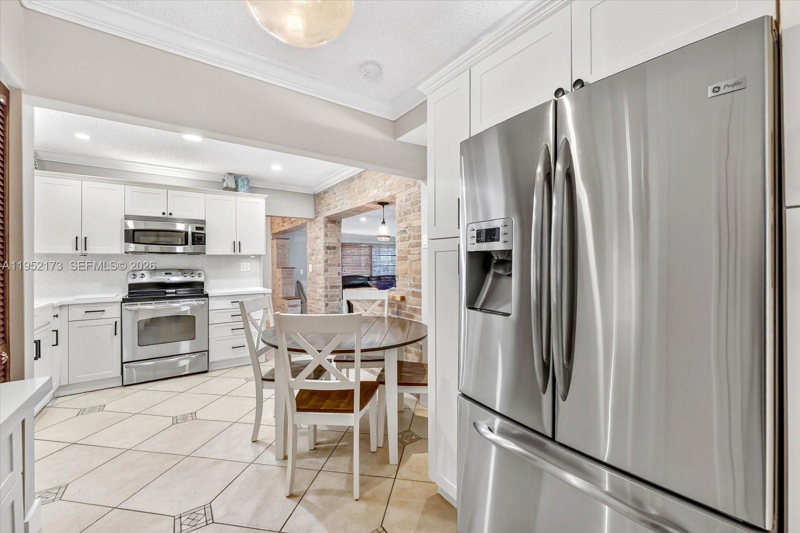 1300 West 77th Street Hialeah, FL 33014 - Photo 14 of 41 a kitchen with stainless steel appliances a refrigerator and a stove top oven