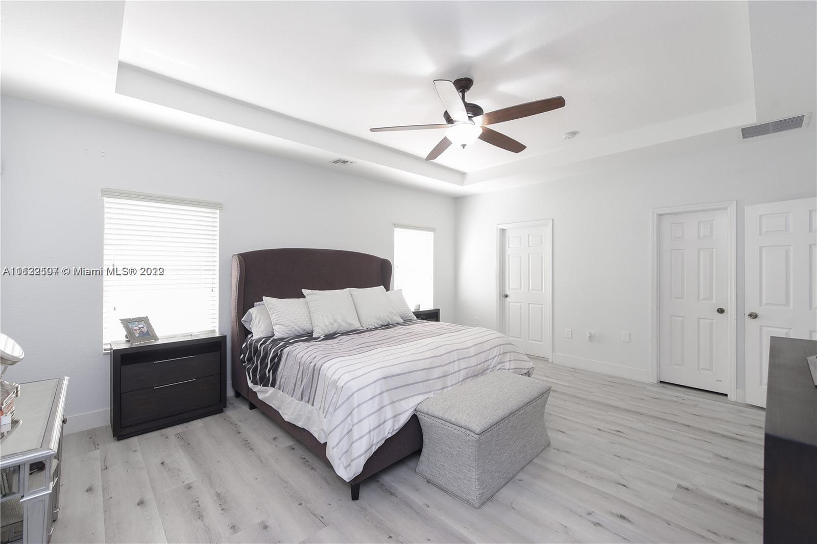 24221 Southwest 112th Court Homestead, FL 33032 - Photo 14 of 25 a bedroom with a bed and a chandelier