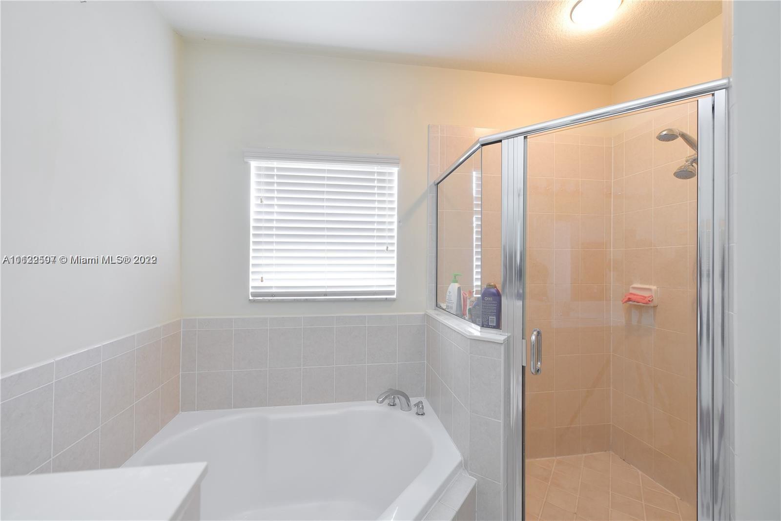 24221 Southwest 112th Court Homestead, FL 33032 - Photo 17 of 25 a bathroom with a bathtub and a shower