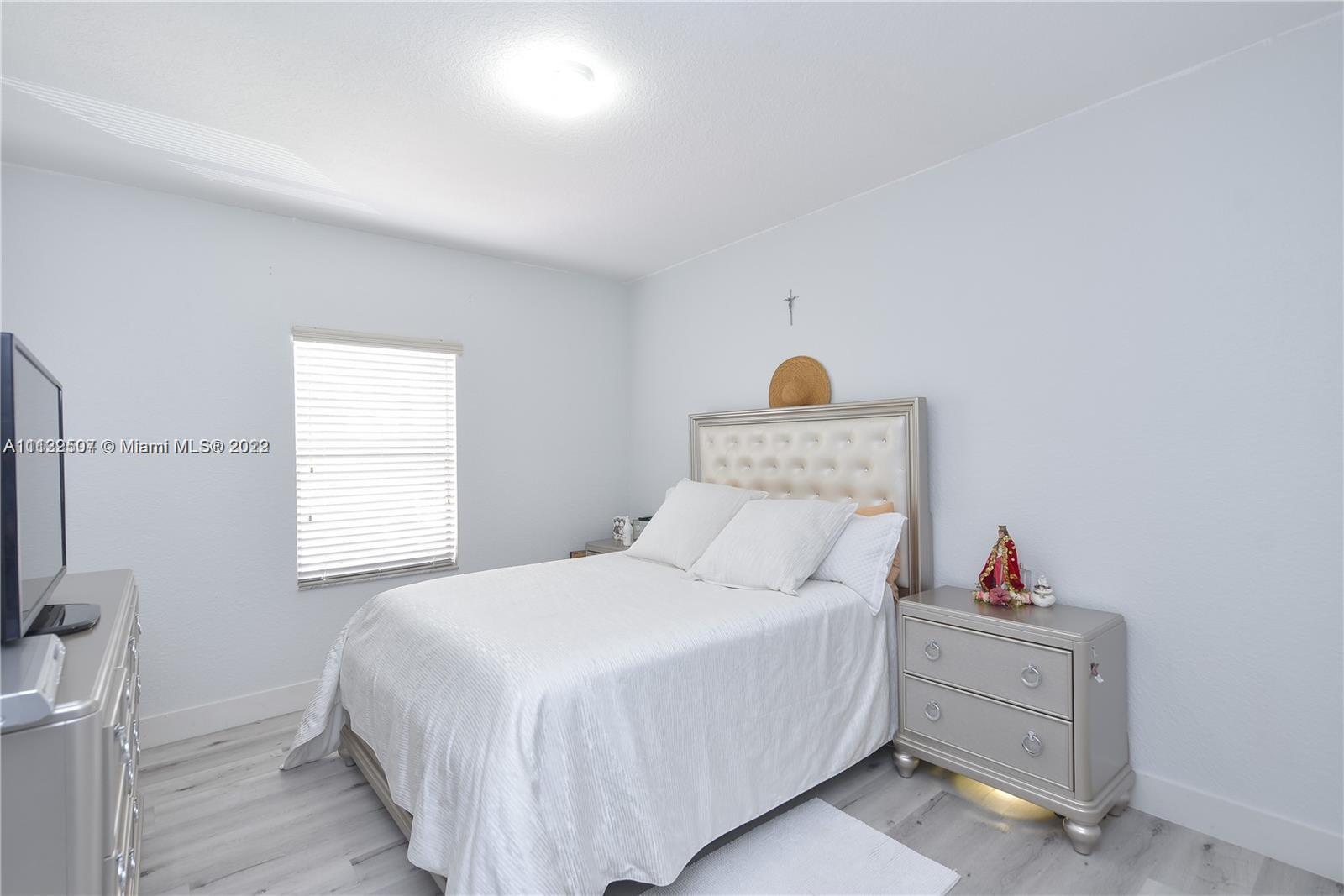 24221 Southwest 112th Court Homestead, FL 33032 - Photo 18 of 25 a bedroom with a bed and a window