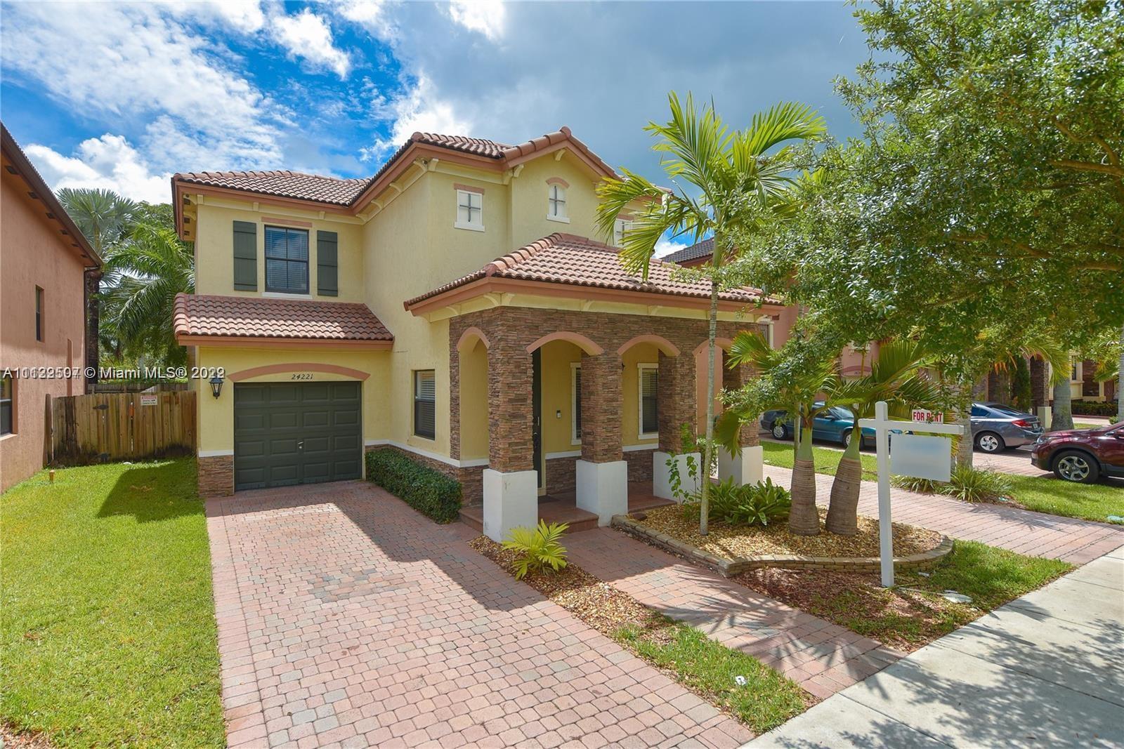 24221 Southwest 112th Court Homestead, FL 33032 - Photo 3 of 25 a front view of a house with a garden and trees