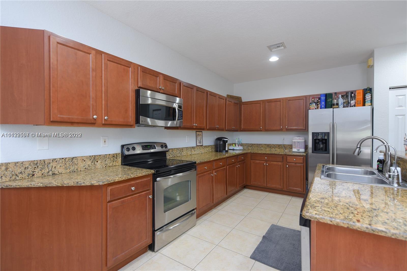 24221 Southwest 112th Court Homestead, FL 33032 - Photo 5 of 25 a kitchen with stainless steel appliances granite countertop a sink stove and oven