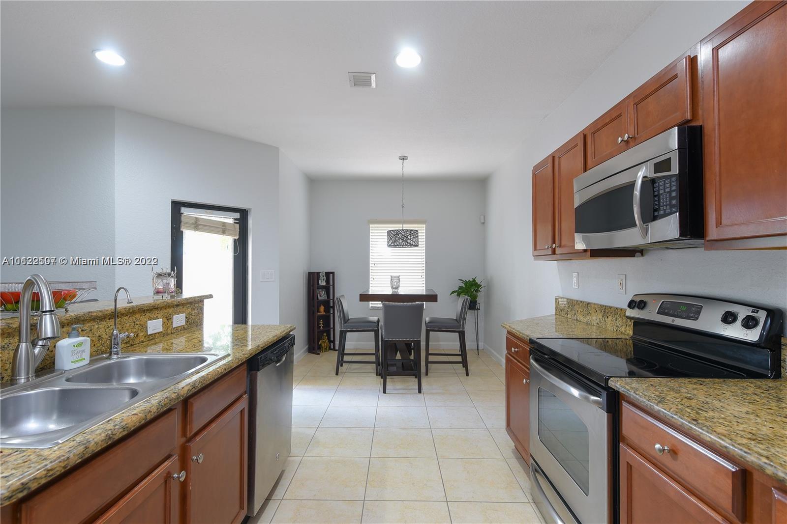 24221 Southwest 112th Court Homestead, FL 33032 - Photo 8 of 25 a kitchen with stainless steel appliances granite countertop a sink and stove