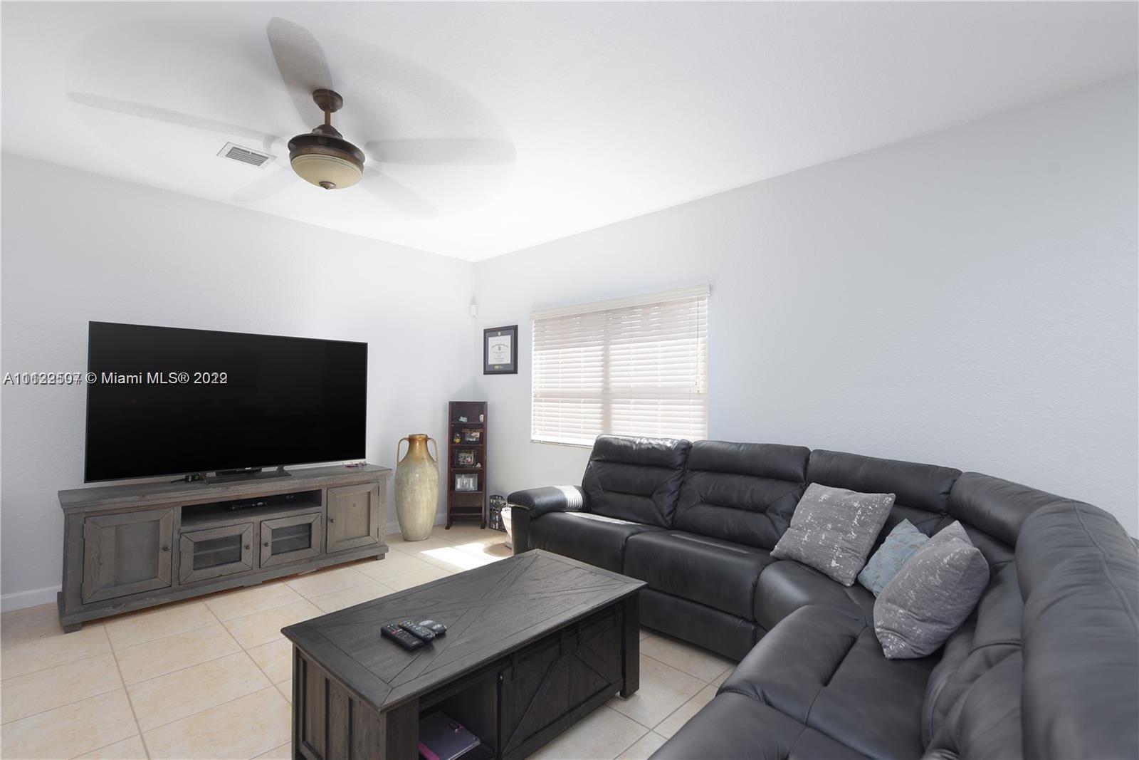 24221 Southwest 112th Court Homestead, FL 33032 - Photo 10 of 25 a living room with furniture and a flat screen tv