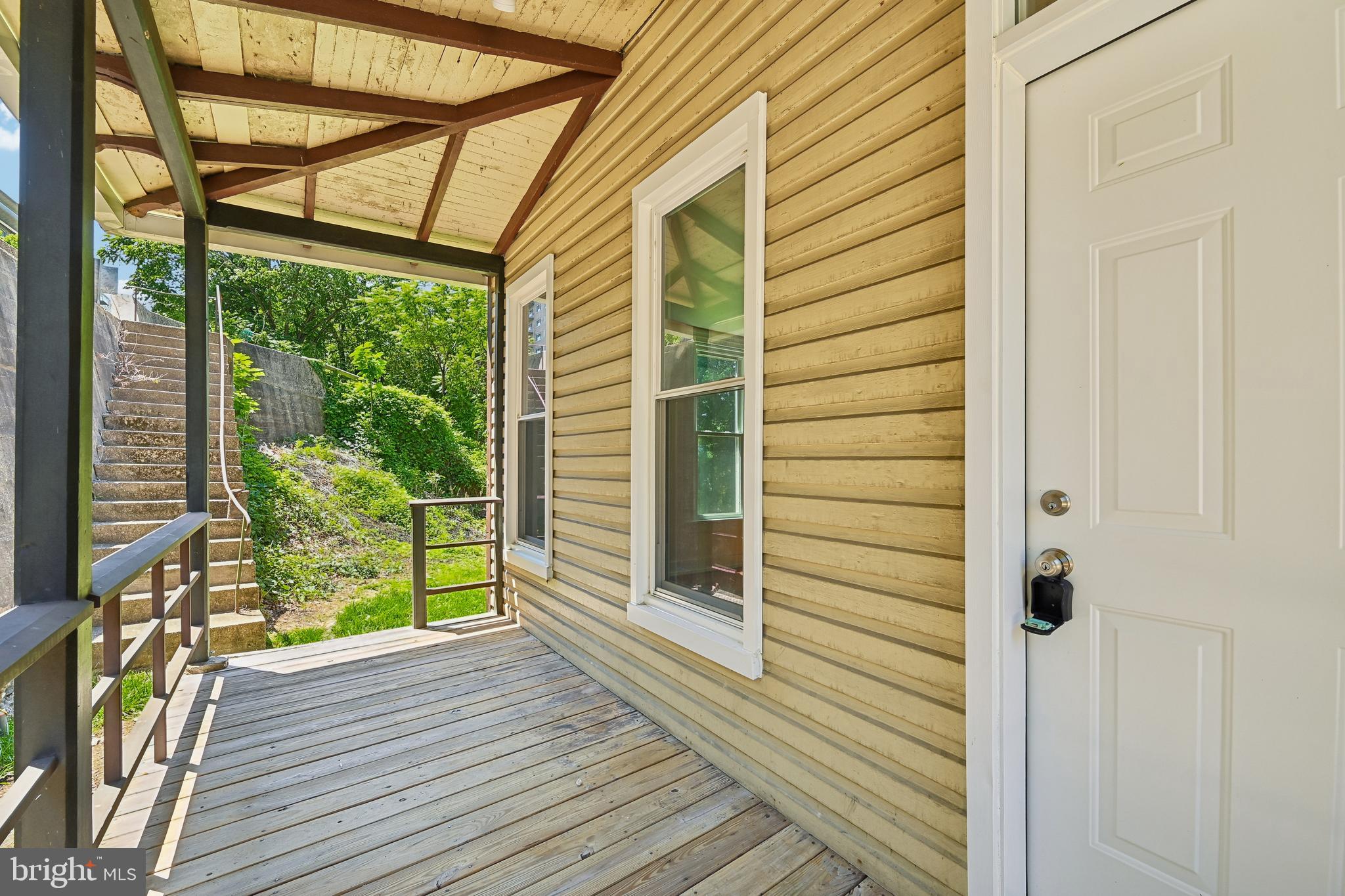 5702 Falls Road Baltimore, MD 21209 - Photo 7 of 49 a view of a porch with wooden floor and stairs