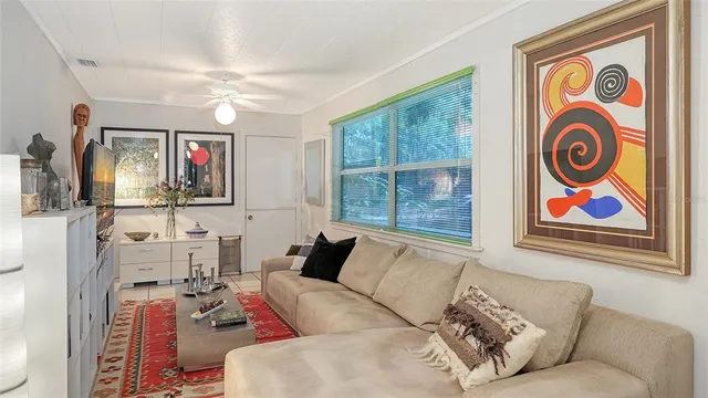 a living room with furniture a flat screen tv and a large window