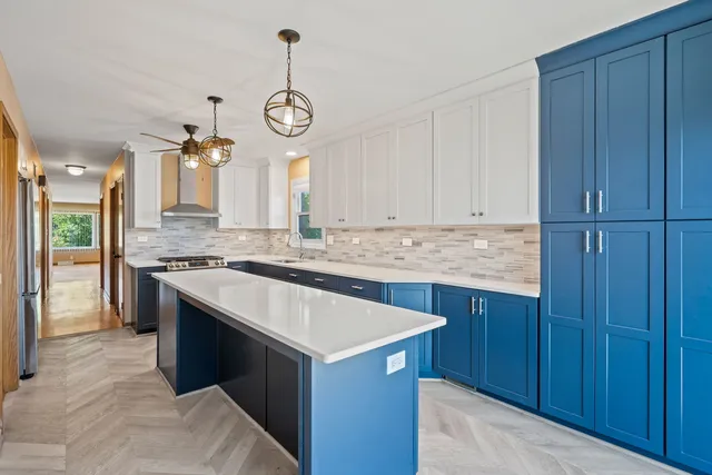 a kitchen with granite countertop a sink cabinets stainless steel appliances and a chandelier
